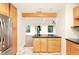 Bright kitchen with center island, stainless steel refrigerator, and wood-look flooring in the adjacent room at 25888 Se 157Th Ln, Umatilla, FL 32784