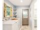 Laundry room featuring a washer, dryer, shelves, window, and an exterior door at 25888 Se 157Th Ln, Umatilla, FL 32784
