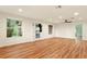 Open-concept living room with wood-look flooring, large windows, and a sliding glass door to the backyard at 25888 Se 157Th Ln, Umatilla, FL 32784