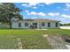 Spacious backyard featuring a patio with a grill and ample green space at 314 Stone Castle Loop, Lady Lake, FL 32159