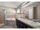 Relaxing bathroom features a double sink vanity, soaking tub, and tiled shower with glass door at 314 Stone Castle Loop, Lady Lake, FL 32159