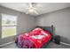 Cozy bedroom featuring neutral gray walls, a ceiling fan, and a comfortable bed with a floral blanket at 314 Stone Castle Loop, Lady Lake, FL 32159