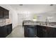 Kitchen with dark wood cabinetry, stainless steel dishwasher, with an adjacent dining area and living space at 314 Stone Castle Loop, Lady Lake, FL 32159