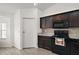 Kitchen with black appliances, wood-look tile flooring, and dark wood cabinetry at 314 Stone Castle Loop, Lady Lake, FL 32159
