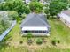Aerial view of home with large green yard, screened patio, well maintained landscaping, and neighborhood at 3213 White Blossom Ln, Clermont, FL 34711
