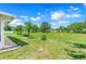 Expansive backyard featuring lush green grass and a charming palm tree set against a vibrant blue sky at 3213 White Blossom Ln, Clermont, FL 34711