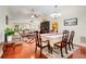Open-concept dining and living area with hardwood floors, elegant furnishings, and bright natural light at 3213 White Blossom Ln, Clermont, FL 34711