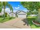 Beautiful single-story home featuring a well-manicured lawn and a two-car garage with a long driveway at 3213 White Blossom Ln, Clermont, FL 34711