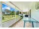 Covered porch featuring tile flooring, a table, and views of the lush backyard with a palm tree at 3213 White Blossom Ln, Clermont, FL 34711