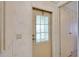 An interior door with a curtain-covered window in a room with floral wallpaper at 32339 Oak Park Dr, Leesburg, FL 34748