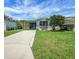 Charming blue home with well-maintained lawn and carport, perfect for easy parking at 32339 Oak Park Dr, Leesburg, FL 34748