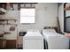 Laundry room includes a washing machine, dryer, window, and wall shelving at 32339 Oak Park Dr, Leesburg, FL 34748