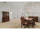 Open-concept dining room featuring neutral carpet, a stylish chandelier, and plenty of natural light at 3605 Kingswood Ct, Clermont, FL 34711