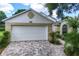 Beautful home exterior featuring a two-car garage with brick driveway and well-maintained landscaping at 3605 Kingswood Ct, Clermont, FL 34711