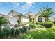 Attractive home exterior with manicured lawn, lush landscaping, and charming front walkway at 3605 Kingswood Ct, Clermont, FL 34711
