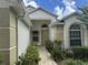 Inviting front entrance featuring manicured bushes and a tiled walkway leading to the front door at 3605 Kingswood Ct, Clermont, FL 34711