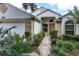 Charming home exterior showcasing a brick pathway, lush landscaping, and inviting front door at 3605 Kingswood Ct, Clermont, FL 34711