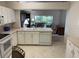 Kitchen featuring tiled floors, white appliances, and large pass through to the living room at 3605 Kingswood Ct, Clermont, FL 34711