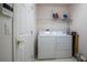 Practical laundry room equipped with a washer, dryer, and storage shelf at 3605 Kingswood Ct, Clermont, FL 34711