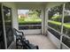 Screened patio with two chairs and view of beautifully landscaped lawn with manicured hedges at 3605 Kingswood Ct, Clermont, FL 34711