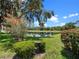 Scenic backyard featuring well-manicured lawn, a pond view, and blooming foliage at 4814 Saint Andrews Arc, Leesburg, FL 34748
