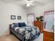 Comfortable bedroom features a cozy bed with quilt, dresser, two windows and neutral colored walls at 4814 Saint Andrews Arc, Leesburg, FL 34748