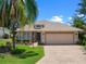Charming single Gathering home boasting a lush lawn, mature trees, and a paved driveway on a sunny day at 4814 Saint Andrews Arc, Leesburg, FL 34748