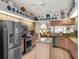 Spacious kitchen featuring stainless steel appliances, granite countertops, an island, and a view into the living area at 4814 Saint Andrews Arc, Leesburg, FL 34748
