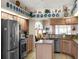 Well-lit kitchen featuring stainless steel appliances, granite countertops, and an island, plus a view into the living area at 4814 Saint Andrews Arc, Leesburg, FL 34748