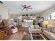 Open-concept living room featuring a ceiling fan, wood floors, and views into the dining and kitchen areas at 4814 Saint Andrews Arc, Leesburg, FL 34748