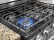 Close-up of a gas stove top burner with blue flame, showcasing the cooking appliance at 4814 Saint Andrews Arc, Leesburg, FL 34748