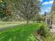 Manicured lawn with mature trees provides a serene backdrop to the home at 487 Thistledown Way, The Villages, FL 32162