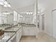 Dual sink bathroom with decorative granite countertops, white cabinets, and ample lighting at 487 Thistledown Way, The Villages, FL 32162