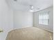 Bright bedroom features neutral carpet, a ceiling fan, and a large window at 487 Thistledown Way, The Villages, FL 32162