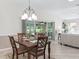 Dining area with chandelier, dark wood table and backyard views at 487 Thistledown Way, The Villages, FL 32162