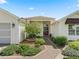 A beautifully landscaped walkway leads to the front door at 487 Thistledown Way, The Villages, FL 32162