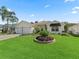 Charming home features a landscaped front yard, complete with a two-car garage at 487 Thistledown Way, The Villages, FL 32162