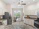 Bright kitchen with stainless appliances, white cabinetry, and an eat-in dining area with backyard views at 487 Thistledown Way, The Villages, FL 32162