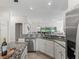 Modern kitchen with granite countertops, stainless steel appliances, and open layout to living spaces at 487 Thistledown Way, The Villages, FL 32162