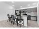 Eat-in kitchen featuring stainless appliances, grey cabinets, a tile backsplash, and modern counter seating at 4874 Noreen Ct, The Villages, FL 32163