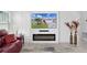 Cozy living room features a modern fireplace and a large screen TV for relaxing entertainment at 4874 Noreen Ct, The Villages, FL 32163