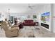 Bright living room featuring a modern fireplace, stylish furniture, and sliding glass doors to a screened patio at 4874 Noreen Ct, The Villages, FL 32163
