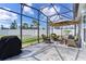 Relaxing screened patio with wicker furniture and view of backyard at 4874 Noreen Ct, The Villages, FL 32163