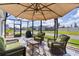 Covered patio featuring cozy seating, shade umbrella, and outdoor grilling space at 4874 Noreen Ct, The Villages, FL 32163