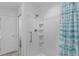 Shower interior with white shower surround, shelving, and blue striped curtain at 4874 Noreen Ct, The Villages, FL 32163