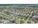 An aerial shot of a neighborhood shows manicured landscaping along with golf course and lake views at 516 Junction Pl, The Villages, FL 32163