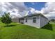 A view of the back of the house shows a screened patio with a lawn that extends beyond the patio's edge at 516 Junction Pl, The Villages, FL 32163