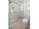 Bathroom featuring a shower with a sliding glass door, tile flooring, and a modern toilet at 516 Junction Pl, The Villages, FL 32163