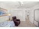 Bedroom with two beds, ceiling fan, area rug, window with blinds, closet, and leather chair at 516 Junction Pl, The Villages, FL 32163
