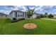 A well manicured front lawn with an ornamental tree is complemented by the home's beautiful landscaping at 516 Junction Pl, The Villages, FL 32163